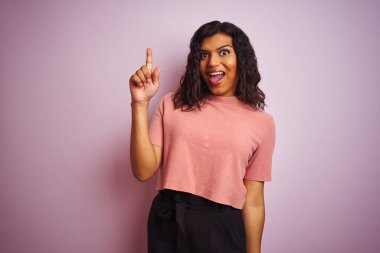 Genç, güzel transseksüel zarif kadın izole edilmiş pembe arka plan üzerinde başarılı bir fikir işaret ediyor. Heyecanlı ve mutlu. Bir numara..
