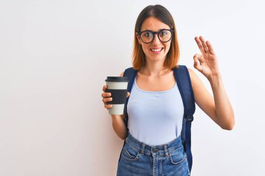 Sırt çantası takıp kahve içen kızıl saçlı güzel bir bayan. Tamam işareti yapıyor. Mükemmel bir sembol.