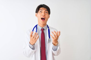 Ceket kravatı takan Çinli doktor ve steteskop ile izole edilmiş beyaz arka planda deli deli deli bağırıyor ve agresif bir ifade ve kollarla bağırıyor. Hayal kırıklığı konsepti.