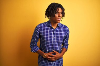 Rastgele gömlek giyen Afro bir adam midesi üstünde sarı arka planda duruyor çünkü hazımsızlık, acı verici bir hastalık ve midesi bulanıyor. Ache kavramı.