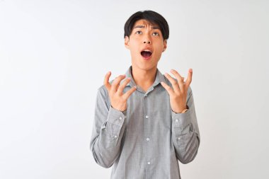 Soyutlanmış beyaz arka plan üzerinde duran şık gömlekli Çinli işadamı kızgın ve çılgın bir şekilde bağırıyor ve agresif bir ifade ve kollarla bağırıyor. Hayal kırıklığı konsepti.