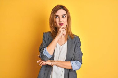 Kızıl saçlı, beyaz iş kadını, sarılar üzerinde izole edilmiş bir geçmişi var. Endişeli ve gergin bir hali var. Endişeli ve şaşırmış bir ifadesi var.