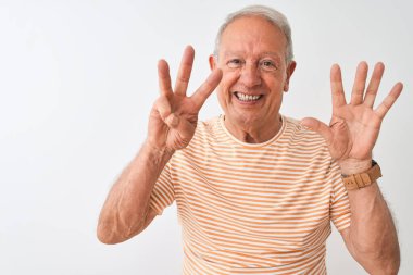 Kıdemli, gri saçlı, çizgili tişört giyen, izole edilmiş beyaz arka planda duran ve 8 numarayı işaret eden, kendinden emin ve mutlu gülümseyen adam..