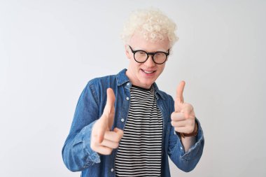 Kot gömlek giyen ve gözlüklü genç sarışın adam izole edilmiş beyaz arka plan üzerinde mutlu ve komik yüzlü parmakları kameraya gösteriyor. İyi enerji ve titreşimler.