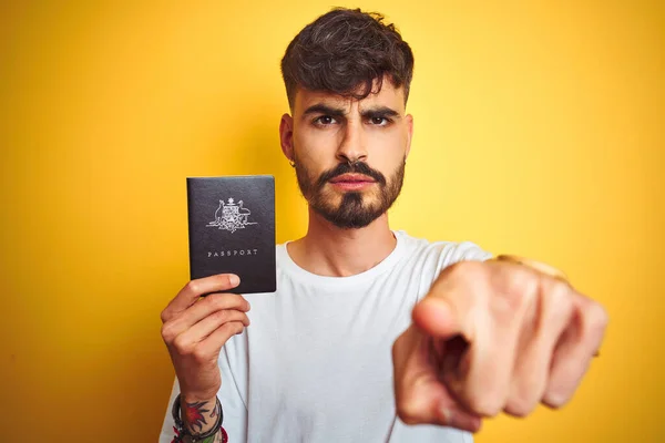 Молодий Чоловік Татуюванням Австралії Паспорт Через Ізольований Жовтий Фон Вказуючи — стокове фото