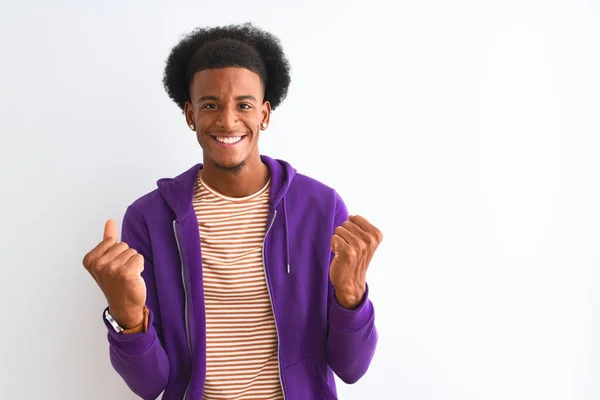 身穿紫色运动衫站在孤立的白色背景之上的非裔美国人 以张开双臂和睁开眼睛庆祝对成功的惊奇和惊奇 赢的概念 — 图库照片