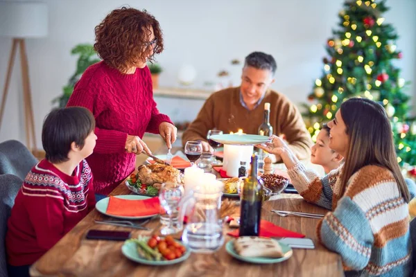 美しい家族の笑顔幸せと自信 彼らのうちの1人は自宅でクリスマスを祝うロースト七面鳥をカーブ — ストック写真