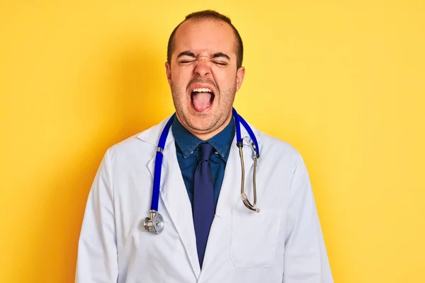 Joven Doctor Vestido Con Abrigo Estetoscopio Parado Sobre Fondo Amarillo —  Fotos de Stock