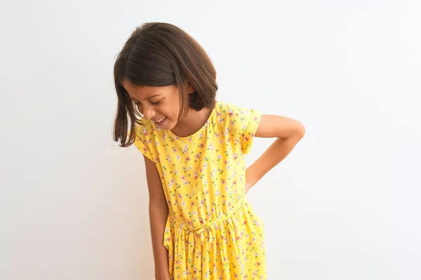 年轻美丽的小女孩穿着黄色的花衣服 站在孤立的白色背景上 用手触摸 肌肉疼痛 — 图库照片
