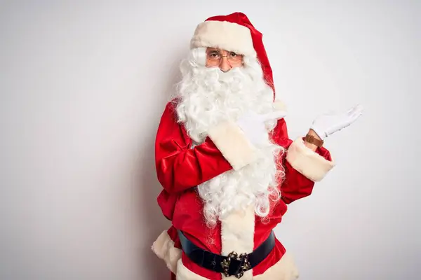 中年男子穿着圣诞老人的服装 站在孤立的白色背景上 面带微笑 手牵着手 指指点点着相机 — 图库照片