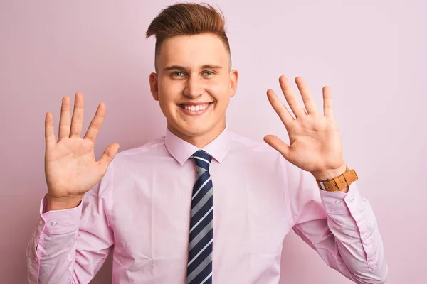 シャツとネクタイを着た若いハンサムなビジネスマンは 自信を持って幸せに微笑みながら 指番号10を示し 指で指を上げる孤立したピンクの背景の上に立って — ストック写真