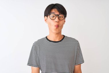 Gözlüklü ve donanma tişörtlü Çinli bir adam izole edilmiş beyaz arka plan üzerinde durup dudaklı balık suratı yapıyor, çılgınca ve komik bir jest. Komik ifade.