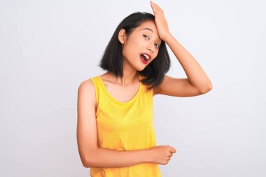 Sarı günlük tişört giyen genç Çinli bir kadın izole edilmiş beyaz arka planda dikilirken yanlışlıkla el ele tutuşarak şaşırdı. Hatayı hatırla. Unuttum, kötü hafıza konsepti.