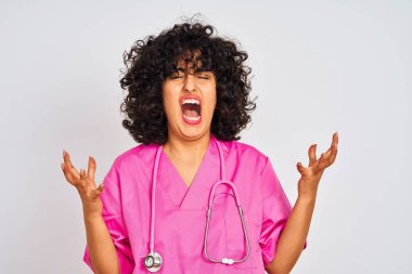 Genç, kıvırcık saçlı, steteskop takmış Arap doktor kadın izole edilmiş beyaz arka planda başarıyı kutluyor kollarını kaldırmış ve gözlerini kapatmış heyecanlı çığlıklar atıyor. Kazanan konsept
