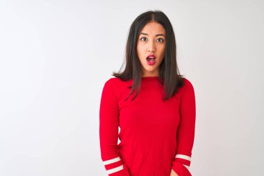 İzole edilmiş beyaz arka planda duran kırmızı elbiseli genç, güzel Çinli kadın korku ve şaşkınlık dolu bir ifadeyle ürkmüş ve şok olmuştu..