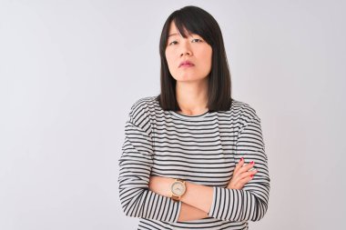 İzole edilmiş beyaz arka plan üzerinde siyah çizgili tişört giyen genç, güzel Çinli kadın şüpheci ve gergin, yüzünde çapraz kollu tasvip etmeyen bir ifade var. Negatif kişi.