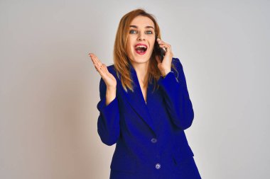 Kafkasyalı zarif iş kadını izole bir arka planda konuşuyor mutlu ve heyecanlı, kazanan ifade zaferi büyük bir gülümsemeyle kutluyor ve ellerini kaldırıyor.