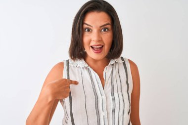 İzole edilmiş beyaz arka planda dikilen sıradan çizgili tişört giyen genç ve güzel bir kadın kendini gösteren sürpriz bir yüzle.