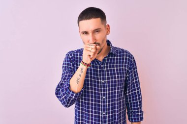 Soyutlanmış arka planda duran yakışıklı genç adam kendini iyi hissetmiyor ve soğuk algınlığı veya bronşitin belirtisi olarak öksürüyor. Sağlık hizmetleri kavramı.