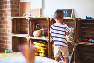 Anaokulunda plastik sepetle oynayan güzel çocuk.