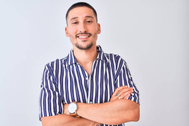 Deniz çizgili tişört giyen yakışıklı genç adam izole edilmiş arka planda durmuş kollarını kavuşturup kameraya bakarken gülümsüyor. Pozitif kişi.
