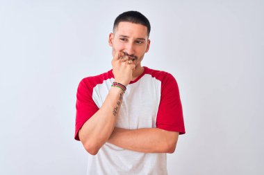 Tecrit edilmiş arka planda duran yakışıklı genç adam gergin ve gergin görünüyor. Ağzı tırnak yiyen eller. Endişe sorunu.