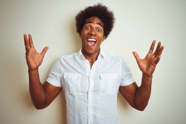 Afro saçlı Afro-Amerikalı bir adam izole edilmiş beyaz arka plan üzerinde duruyor çılgın ve sinirli bir şekilde bağırıyor ve agresif bir ifade ve kollar havada bağırıyor. Hayal kırıklığı konsepti.