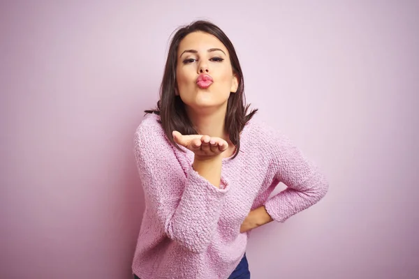 Młoda Piękna Brunetka Ubrana Sweter Różowym Tle Patrząca Kamerę Dmuchająca — Zdjęcie stockowe