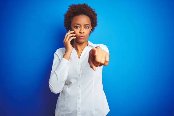 Africano Americano Mulher Falando Smartphone Sobre Fundo Isolado Azul Apontando — Fotografia de Stock