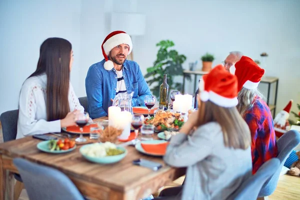 サンタの帽子をかぶっている美しい家族は笑顔で自信を持っています 自宅でクリスマスを祝うロースト七面鳥を食べる — ストック写真