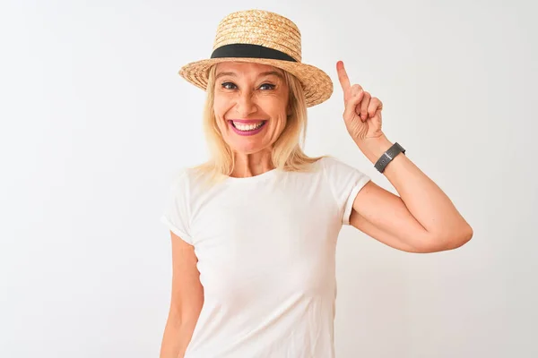 中年妇女穿着休闲装 头戴帽子 站在孤零零的白色背景上 指指点点 想出了个好主意 又兴奋又快乐 第一部分 — 图库照片