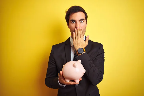 Jovem Empresário Bonito Segurando Porquinho Banco Sobre Isolado Amarelo Fundo — Fotografia de Stock