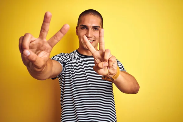 Mladý Pohledný Muž Pruhovaném Tričku Přes Žluté Izolované Pozadí Usmívající — Stock fotografie
