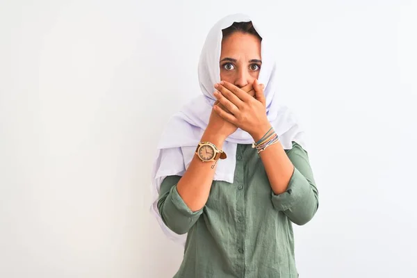 孤立した背景の上に伝統的なイスラム教徒のヒジャーブを身に着けている若い美しいアラブの女性は間違いのための手で口をカバーショックを受けた 秘密概念 — ストック写真