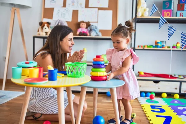 Young Beautiful Teacher Toddler Building Pyramid Using Hoops Table Kindergarten — Stock Photo, Image