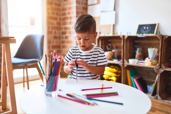 美しい幼児の男の子は幼稚園で色鉛筆を使ってかわいい絵を描く — ストック写真