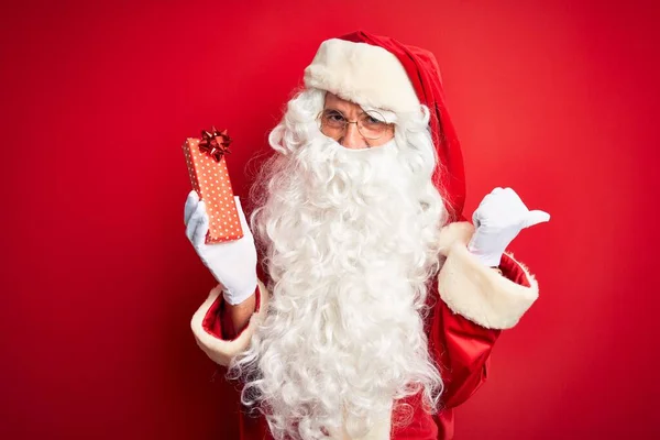 Middle Age Man Wearing Santa Claus Costume Holding Gift Isolated — Zdjęcie stockowe