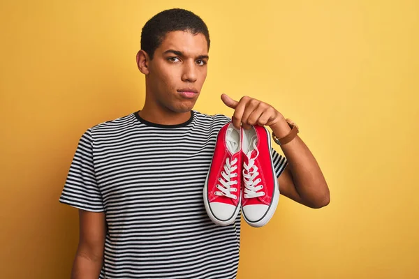 Yakışıklı Arap Genç Adam Sıradan Spor Ayakkabıları Tutuyor Zole Edilmiş — Stok fotoğraf