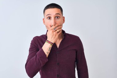 Tecrit edilmiş arka planda duran genç ve yakışıklı bir iş adamı ağzının üstünü yanlışlıkla ellerle kapatarak şok geçirdi. Gizli konsept.