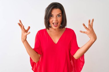 Kırmızı tişört giyen genç güzel kadın izole beyaz arka plan üzerinde duran deli kutluyor ve kollarını kaldırdı ve açık gözleri heyecan çığlık ile başarı için hayran. Kazanan kavramı