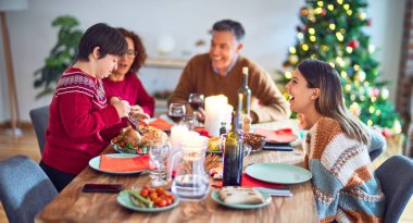 Mutlu ve kendinden emin gülümseyen güzel bir aile. Kavrulmuş hindilerden biri evde Noel 'i kutluyor.