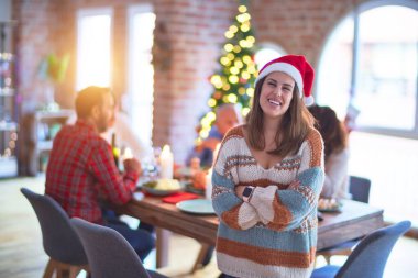 Mutlu ve kendinden emin gülümseyen genç ve güzel bir kadın. Noel Baba şapkası takmış, Noel 'i ailenle birlikte kutluyorsun.