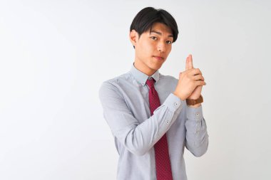 Beyaz arka planda duran zarif kravat takan Çinli bir işadamı sembolik bir silahı el hareketleriyle tutuyor, cinayet silahlarıyla oynuyor, kızgın bir yüz takınıyor.