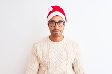 Yılbaşı şapkası ve gözlüğü takan genç yakışıklı bir adam izole bir arka plan ve yüzünde ciddi bir ifadeyle. Basit ve doğal bir şekilde kameraya bakıyorsun..