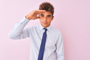 Gömlek ve kravat takan genç yakışıklı iş adamı pembe arka planda duruyor. Alnındaki sorun yüzünden endişeli ve stresli. Kriz konusunda endişeli.