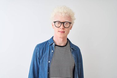 Kotlu gömlek ve gözlük takan genç sarışın adam izole edilmiş beyaz arka plan üzerinde rahatlamış ve yüzünde ciddi bir ifade vardı. Basit ve doğal bir şekilde kameraya bakıyorsun..