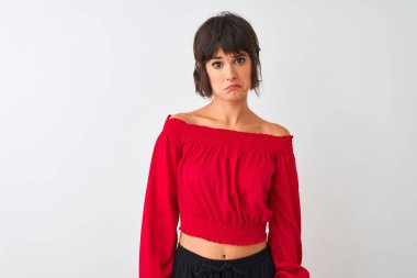 Kırmızı yaz tişörtü giyen genç ve güzel bir kadın izole edilmiş beyaz arka planda duruyor. Depresyonda ve endişe içinde, kızgın ve korkmuş bir şekilde ağlıyor. Üzücü ifade.