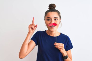 İzole edilmiş beyaz bir zemin üzerinde popo partisi bıyığı tutan genç ve güzel bir kadın bir fikir veya soru işareti ile şaşırdı mutlu yüzle, bir numara