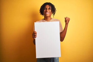 İzole sarı arka plan üzerine bayrağı tutan dreadlocks ile Afro Amerikan adam gururlu çığlık ve zafer ve başarı çok heyecanlı kutluyor, duygu tezahürat