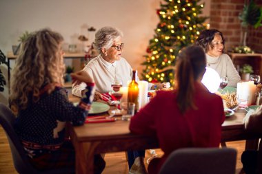 Mutlu ve kendinden emin gülümseyen güzel bir kadın grubu. Evde kızarmış hindi yiyip Noel 'i kutluyoruz.